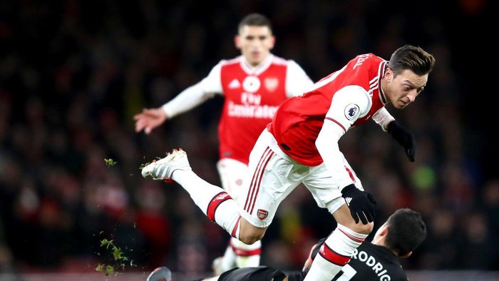 LONDON, ENGLAND - DECEMBER 15: Mesut Ozil of Arsenal is challenged by Rodrigo of Manchester City during the Premier League match between Arsenal FC and Manchester City at Emirates Stadium on December 15, 2019 in London, United Kingdom. (Photo by Julian Finney/Getty Images)