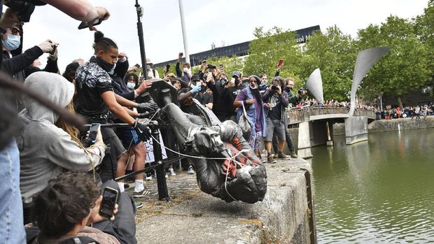 Patung Edward Colston Protesters throw a statue of slave trader Edward Colston into Bristol harbour, during a Black Lives Matter protest rally, in Bristol, England, Sunday June 7, 2020, in response to the recent killing of George Floyd by police officers in Minneapolis, USA, that has led to protests in many countries and across the US. (Ben Birchall/PA via AP)