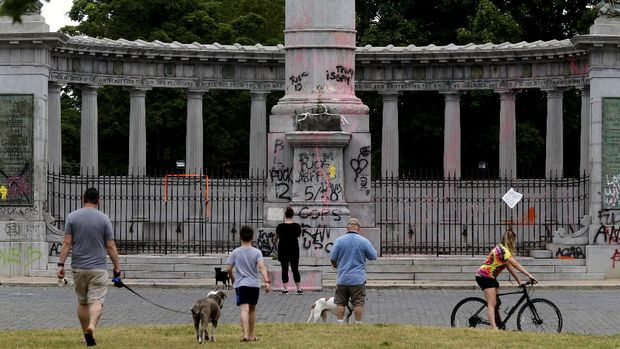 patung Jefferson Davis People gathered at the Jefferson Davis monument on Monument Ave. Thursday morning, June 11, 2020 after the statue was pulled down by rioters the Wednesday evening. (Bob Brown/Richmond Times-Dispatch via AP)