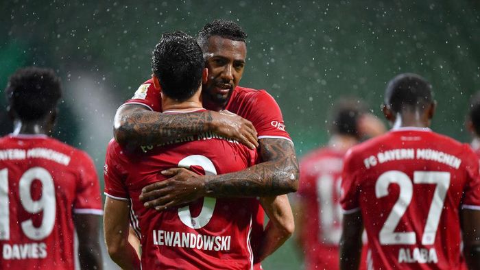 1250089338 BREMEN, GERMANY - JUNE 16: Robert Lewandowski of Bayern Munich celebrates with teammate Jerome Boateng of Bayern Munich after scoring his teams first goal during the Bundesliga match between SV Werder Bremen and FC Bayern Muenchen at Wohninvest Weserstadion on June 16, 2020 in Bremen, Germany. (Photo by Stuart Franklin/Getty Images)