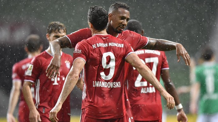 Bayerns Robert Lewandowski, foreground, celebrates with his teammate Bayerns Jerome Boateng after scoring his sides opening goal during the German Bundesliga soccer match between Werder Bremen and Bayern Munich in Bremen, Germany, Tuesday, June 16, 2020. Because of the coronavirus outbreak all soccer matches of the German Bundesliga take place without spectators. (AP Photo/Martin Meissner, Pool)