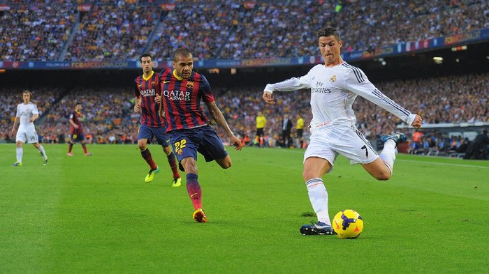 BARCELONA, SPAIN - OCTOBER 26:  Cristiano Ronaldo of Real Madrid CF (R) crosses the ball beside Dani Alves of FC Barcelona during the La Liga match between FC Barcelona and Real Madrid CF at Camp Nou stadium on October 26, 2013 in Barcelona, Spain.  (Photo by Denis Doyle/Getty Images)