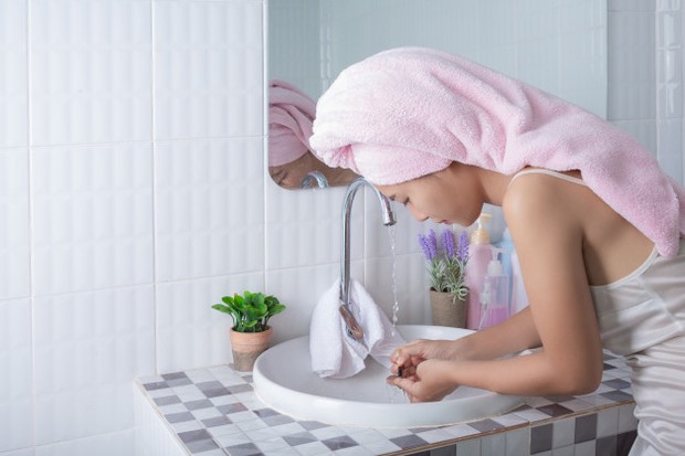 Membilas wajah dengan air setelah menggunakan cleansing oil