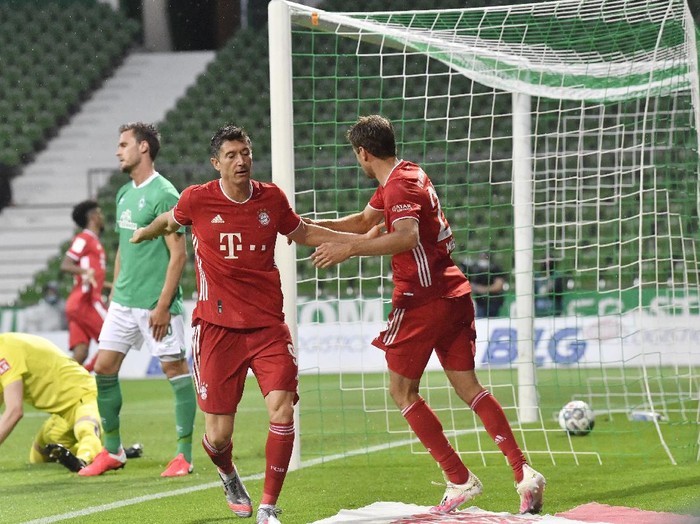 Bayerns Robert Lewandowski, second right, celebrates with Bayerns Thomas Mueller after scoring a goal later disallowed for offside during the German Bundesliga soccer match between Werder Bremen and Bayern Munich in Bremen, Germany, Tuesday, June 16, 2020. Because of the coronavirus outbreak all soccer matches of the German Bundesliga take place without spectators. (AP Photo/Martin Meissner, Pool)