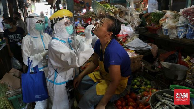 Petugas medis Puskesmas Kecamatan Gambir mengambil sampel lendir warga saat tes Swab di Pasar Thomas,  Jakarta, Rabu, 17 Juni 2020. Tes swab untuk memutus mata rantai penyebaran Covid-19 itu diperuntukan bagi para pedagang pasar. CNN Indonesia/Safir Makki