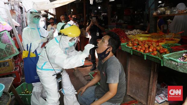 Petugas medis Puskesmas Kecamatan Gambir mengambil sampel lendir warga saat tes Swab di Pasar Thomas,  Jakarta, Rabu, 17 Juni 2020. Tes swab untuk memutus mata rantai penyebaran Covid-19 itu diperuntukan bagi para pedagang pasar. CNN Indonesia/Safir Makki