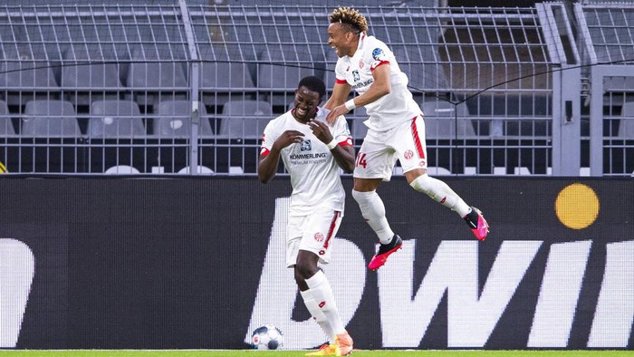 Mainzs scorer Jean-Philippe Mateta, left, and his teammate Pierre Kunde Malong, right, celebrate their sides second goal during the German Bundesliga soccer match between Borussia Dortmund and 1. FSV Mainz 05 in Dortmund, Germany, Wednesday, June 17, 2020. (Guido Kirchner/DPA via AP, Pool)