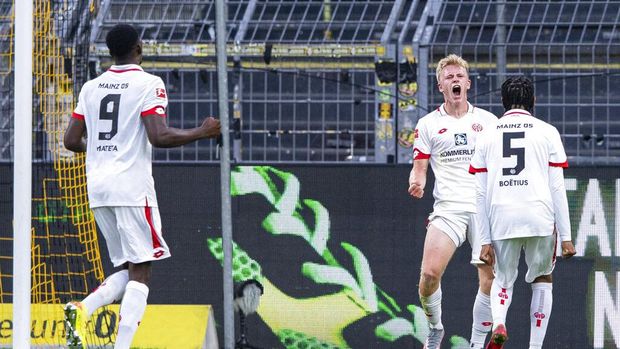 Mainz's Jonathan Burkardt, second right, celebrates after scoring the opening goal during the German Bundesliga soccer match between Borussia Dortmund and 1. FSV Mainz 05 in Dortmund, Germany, Wednesday, June 17, 2020. (Guido Kirchner/DPA via AP, Pool)