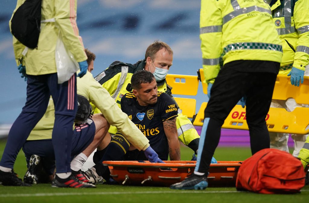 MANCHESTER, ENGLAND - JUNE 17: Granit Xhaka of Arsenal reacts as he receives medical treatment before being helped onto a stretcher during the Premier League match between Manchester City and Arsenal FC at Etihad Stadium on June 17, 2020 in Manchester, United Kingdom. (Photo by Dave Thompson/ Pool via Getty Images)