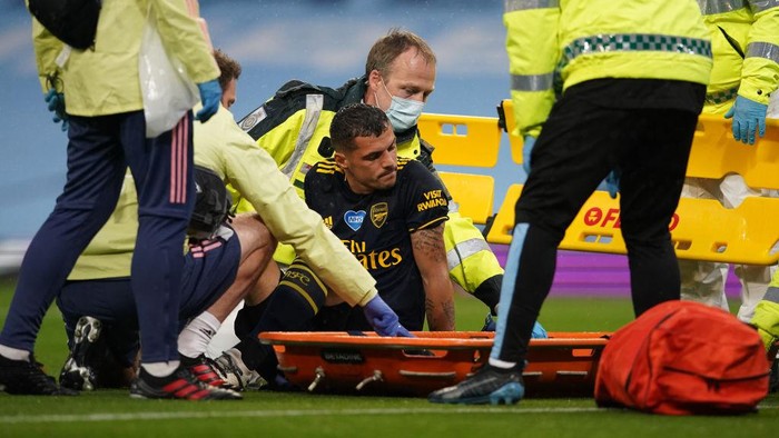 MANCHESTER, ENGLAND - JUNE 17: Granit Xhaka of Arsenal reacts as he receives medical treatment before being helped onto a stretcher during the Premier League match between Manchester City and Arsenal FC at Etihad Stadium on June 17, 2020 in Manchester, United Kingdom. (Photo by Dave Thompson/ Pool via Getty Images)