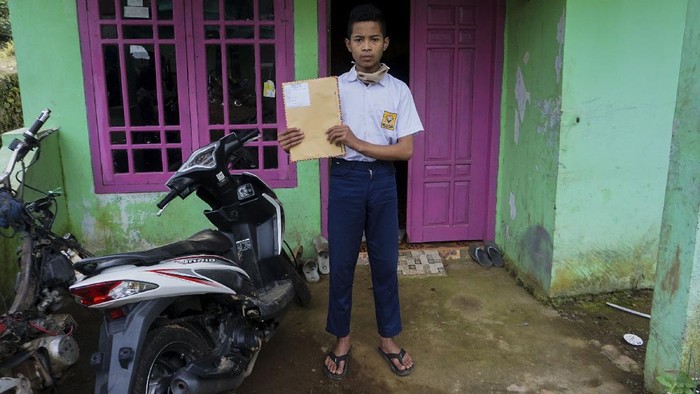 JEMPUT BOLA TUGAS SEKOLAH SAAT PANDEMI COVID-19 Siswa SMP N 4 Bawang, Dani Difanudin, mengerjakan tugas sekolah di rumahnya di Pranten, Kecamatan Bawang, Kabupaten Batang, Jawa Tengah.