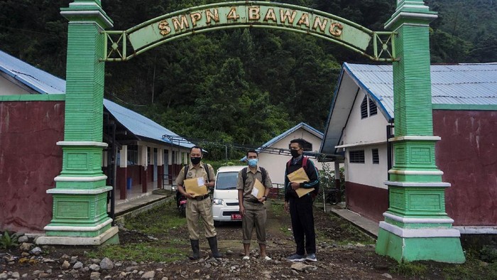 JEMPUT BOLA TUGAS SEKOLAH SAAT PANDEMI COVID-19 Kepala Sekolah SMP N 4 Bawang Mulud Sugito (tengah) dan guru Wiyata Bhakti bersiap melewati aliran sungai di dasar bukit saat mengantar lembar tugas siswa secara langsung ke rumahnya di Pranten, Kecamatan Bawang, Kabupaten Batang, Jawa Tengah.