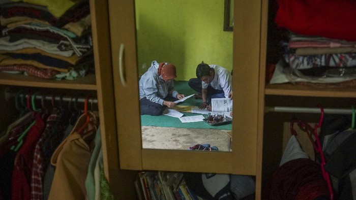 JEMPUT BOLA TUGAS SEKOLAH SAAT PANDEMI COVID-19 Kepala Sekolah SMP N 4 Bawang Mulud Sugito (tengah) dan guru Wiyata Bhakti bersiap melewati aliran sungai di dasar bukit saat mengantar lembar tugas siswa secara langsung ke rumahnya di Pranten, Kecamatan Bawang, Kabupaten Batang, Jawa Tengah.