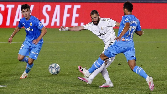 Real Madrids Karim Benzema, center, scores his sides third goal during the Spanish La Liga soccer match between Real Madrid and Valencia at Alfredo di Stefano stadium in Madrid, Spain, Thursday, June 18, 2020. (AP Photo/Manu Fernandez)