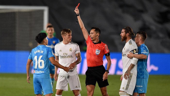 MADRID, SPAIN - JUNE 18:  Lee Kang-In of Valencia CF is shown a red card by referee José María Sánchez Martínez after a tackle on Sergio Ramos of Real Madrid CF during the Liga match between Real Madrid CF and Valencia CF at Estadio Alfredo Di Stefano on June 18, 2020 in Madrid, Spain. (Photo by Denis Doyle/Getty Images)