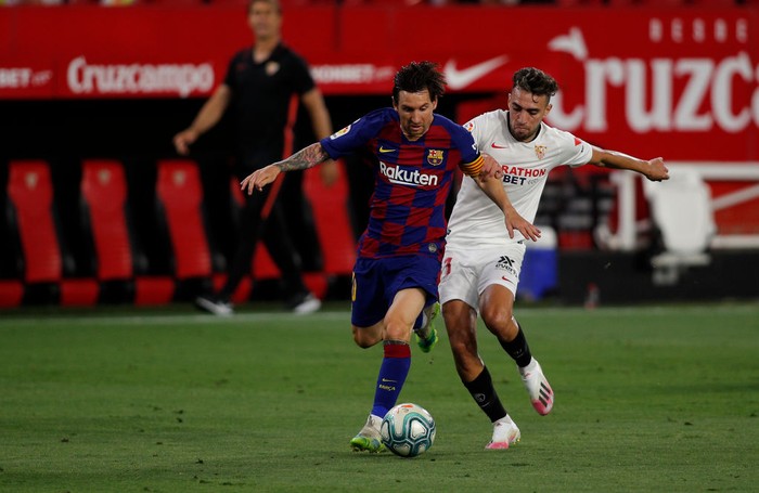 SEVILLE, SPAIN - JUNE 19: Lionel Messi of Barcelona is challenged by Munir El Haddadi of Sevilla during the Liga match between Sevilla FC and FC Barcelona at Estadio Ramon Sanchez Pizjuan on June 19, 2020 in Seville, Spain. (Photo by Fran Santiago/Getty Images)