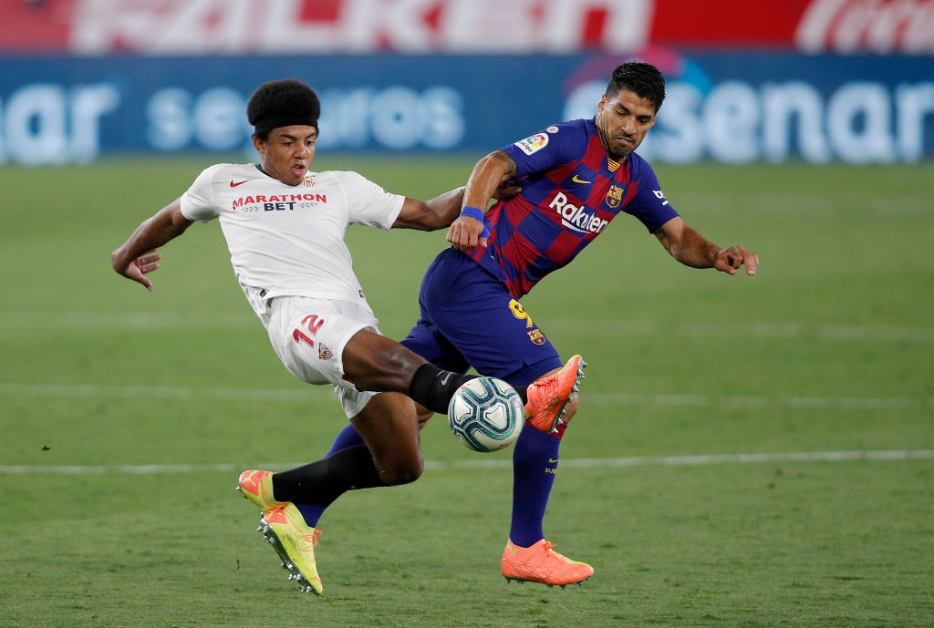 SEVILLE, SPAIN - JUNE 19: Lionel Messi of Barcelona is challenged by Diego Carlos of Sevilla during the Liga match between Sevilla FC and FC Barcelona at Estadio Ramon Sanchez Pizjuan on June 19, 2020 in Seville, Spain. (Photo by Fran Santiago/Getty Images)