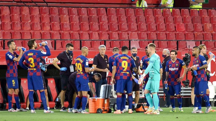 Barcelonas Spanish coach Quique Setien (C) speaks to players during the Spanish league football match between Sevilla FC and FC Barcelona at the Ramon Sanchez Pizjuan stadium in Seville on June 19, 2020. (Photo by CRISTINA QUICLER / AFP)