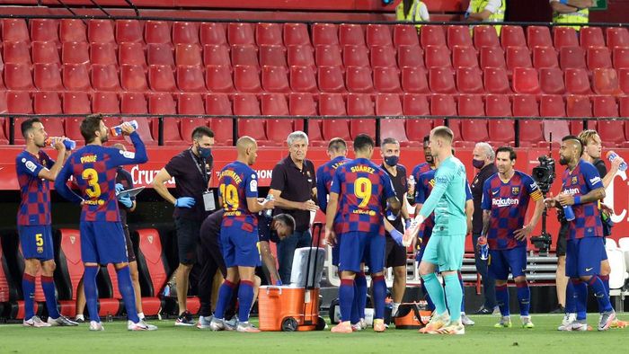 Barcelona Barcelonas Spanish coach Quique Setien (C) speaks to players during the Spanish league football match between Sevilla FC and FC Barcelona at the Ramon Sanchez Pizjuan stadium in Seville on June 19, 2020. (Photo by CRISTINA QUICLER / AFP)