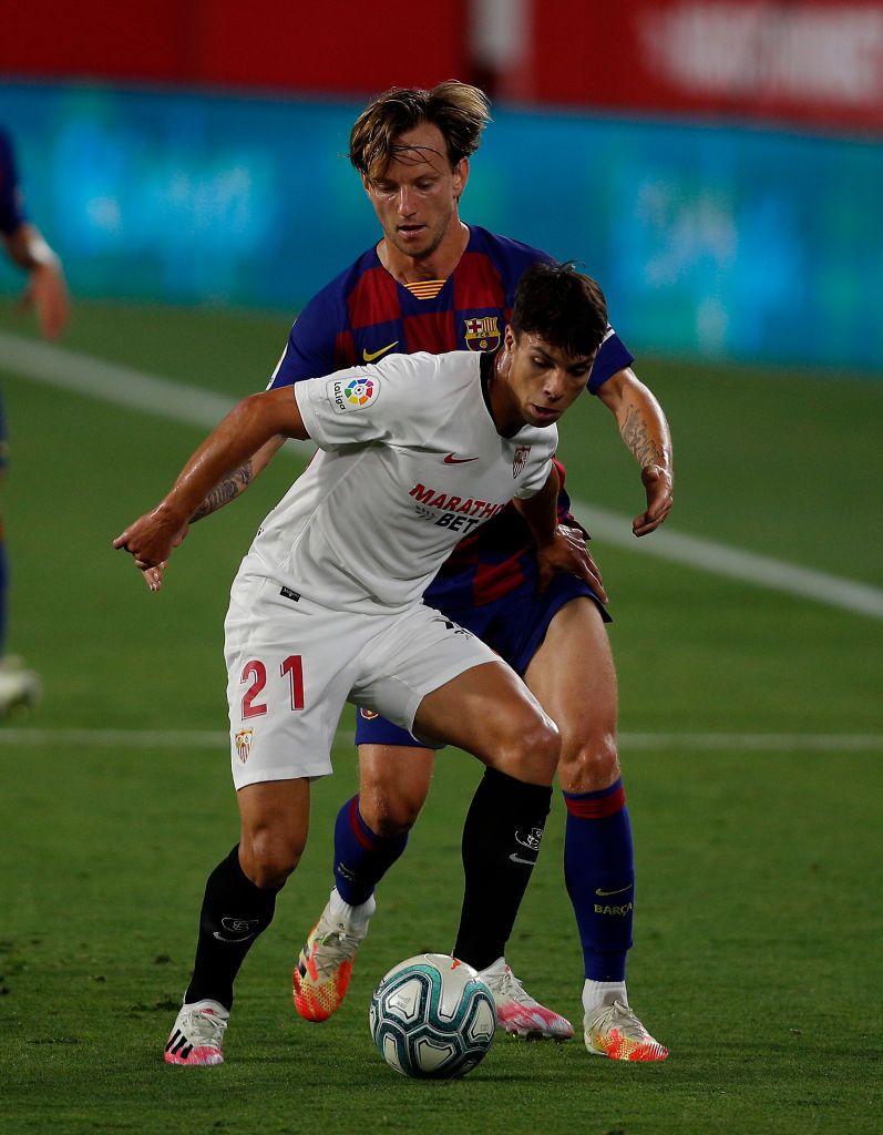 SEVILLE, SPAIN - JUNE 19: Lionel Messi of Barcelona is challenged by Munir El Haddadi of Sevilla during the Liga match between Sevilla FC and FC Barcelona at Estadio Ramon Sanchez Pizjuan on June 19, 2020 in Seville, Spain. (Photo by Fran Santiago/Getty Images)