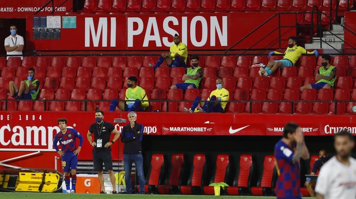 Barcelonas head coach Quique Setien, center left, gestures during the Spanish La Liga soccer match between Sevilla and FC Barcelona at the Ramon Sanchez-Pizjuan stadium in Seville, Spain, Friday, June 19, 2020. (AP Photo/Angel Fernandez)