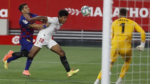 Sevilla vs Barcelona Barcelona's Luis Suarez, left, tries to stop Sevilla's Jules Kounde during the Spanish La Liga soccer match between Sevilla and FC Barcelona at the Ramon Sanchez-Pizjuan stadium in Seville, Spain, Friday, June 19, 2020. (AP Photo/Angel Fernandez)