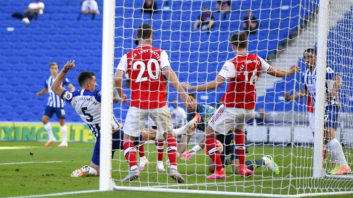 Brightons Lewis Dunk, left, scores his sides first goal during the English Premier League soccer match between Brighton & Hove Albion and Arsenal at the AMEX Stadium in Brighton, England, Saturday, June 20, 2020. (Mike Hewitt/Pool via AP)