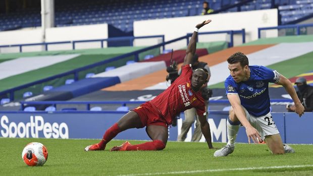 Everton's Seamus Coleman, right, battles for the ball with Liverpool's Sadio Mane during the English Premier League soccer match between Everton and Liverpool at Goodison Park in Liverpool, England, Sunday, June 21, 2020. (Peter Powell/Pool via AP)