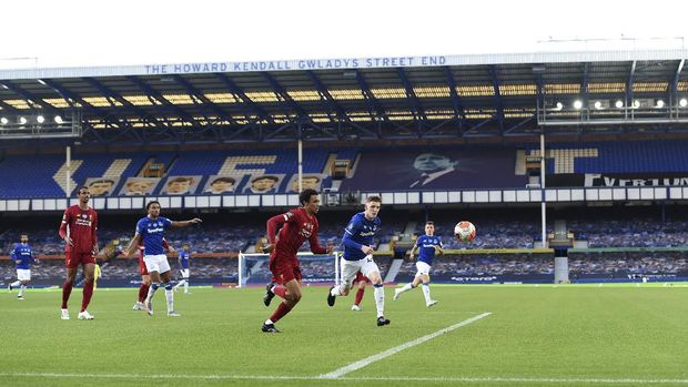 Players play in front of empty stands during the English Premier League soccer match between Everton and Liverpool at Goodison Park in Liverpool, England, Sunday, June 21, 2020. (Peter Powell/Pool via AP)