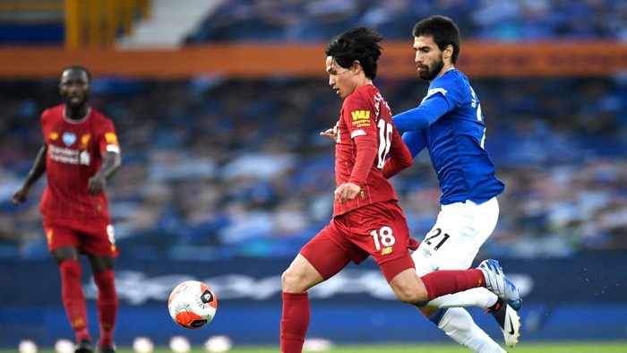 LIVERPOOL, ENGLAND - JUNE 21: Takumi Minamino of Liverpool battles for possession with Andre Gomes of Everton during the Premier League match between Everton FC and Liverpool FC at Goodison Park on June 21, 2020 in Liverpool, England. Football Stadiums around Europe remain empty due to the Coronavirus Pandemic as Government social distancing laws prohibit fans inside venues resulting in all fixtures being played behind closed doors. (Photo by Peter Powell/Pool via Getty Images)