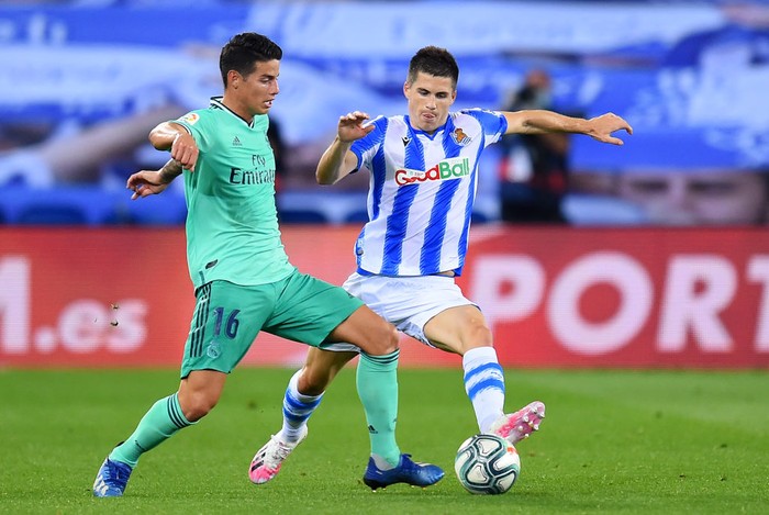 SAN SEBASTIAN, SPAIN - JUNE 21:  James Rodríguez of Real Madrid is tackled by Igor Zubeldia of Real Sociedad during the Liga match between Real Sociedad and Real Madrid CF at Estadio Anoeta on June 21, 2020 in San Sebastian, Spain. (Photo by Juan Manuel Serrano Arce/Getty Images)