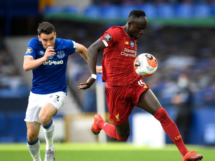 LIVERPOOL, ENGLAND - JUNE 21: Sadio Mane of Liverpool controls the ball as Seamus Coleman of Everton chases during the Premier League match between Everton FC and Liverpool FC at Goodison Park on June 21, 2020 in Liverpool, England. Football Stadiums around Europe remain empty due to the Coronavirus Pandemic as Government social distancing laws prohibit fans inside venues resulting in all fixtures being played behind closed doors. (Photo by Peter Powell/Pool via Getty Images)