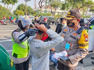 Polisi Bagikan Masker Merah Putih Kepada Pengguna Jalan di Surabaya