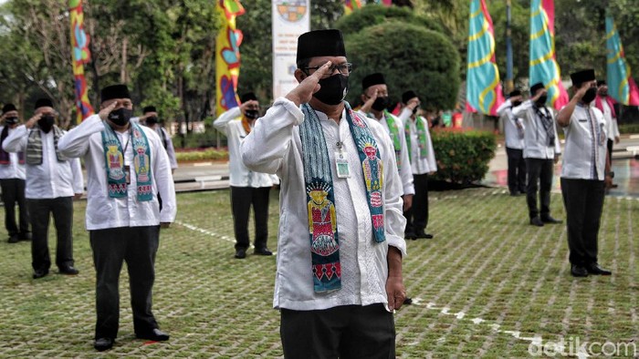 Sejumlah pegawai PNS melakuan  upacara HUT DKI Jakarta ke-493 dengan melakukan protokol kesehatan physical distancing di kawasan kantor Walikota Jakarta Utara, Senin (22/6). Upacara perdana di masa pandemi COVID-19 tersebut hanya melibatkan 50 peserta upacara dan mengutamakan ketentuan protokol kesehatan.