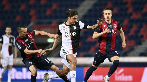 Juventus' Paulo Dybala, center, in action with Bologna's Nicola Sansone, left, during the Serie A soccer match between Bologna FC and Juventus FC at Stadio Renato Dall'Ara stadium in Bologna, Monday June 22, 2020. (Massimo Paolone/LaPresse via AP)