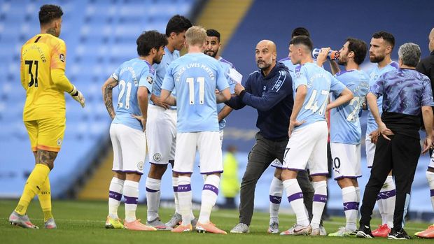 Manchester City's head coach Pep Guardiola gestures as he talks with his players during a drinks break in the English Premier League soccer match between Manchester City and Burnley at Etihad Stadium, in Manchester, England, Monday, June 22, 2020. (AP Photo/Michael Regan,Pool)