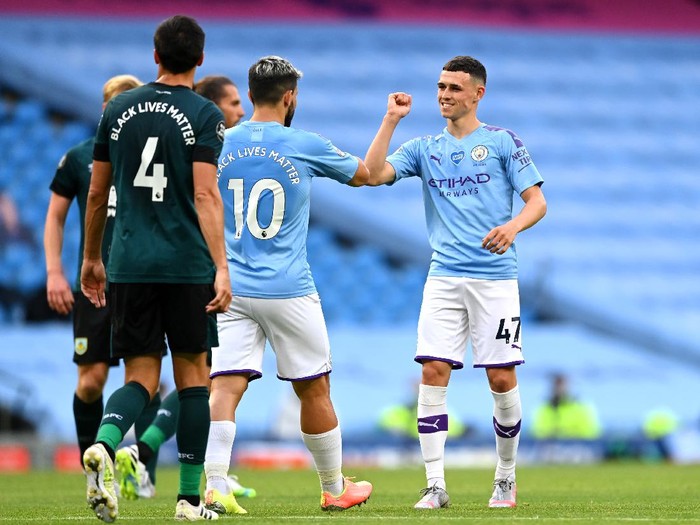 MANCHESTER, ENGLAND - JUNE 22: Phil Foden of Manchester City celebrates with Sergio Aguero of Manchester City after scoring his teams first goal during the Premier League match between Manchester City and Burnley FC at Etihad Stadium on June 22, 2020 in Manchester, England. Football stadiums around Europe remain empty due to the Coronavirus Pandemic as Government social distancing laws prohibit fans inside venus resulting in all fixtures being played behind closed doors. (Photo by Shaun Botterill/Getty Images)