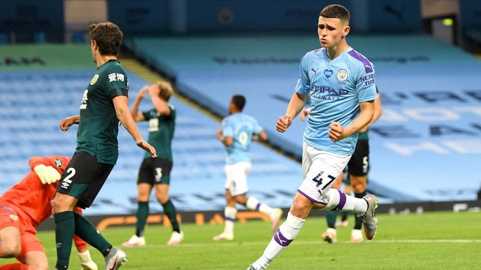 MANCHESTER, ENGLAND - JUNE 22: Phil Foden of Manchester City celebrates after scoring his teams fifth during the Premier League match between Manchester City and Burnley FC at Etihad Stadium on June 22, 2020 in Manchester, England. Football stadiums around Europe remain empty due to the Coronavirus Pandemic as Government social distancing laws prohibit fans inside venus resulting in all fixtures being played behind closed doors. (Photo by Michael Regan/Getty Images)