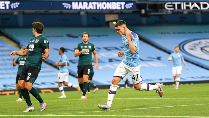 MANCHESTER, ENGLAND - JUNE 22: Phil Foden of Manchester City celebrates after scoring his teams fifth goal during the Premier League match between Manchester City and Burnley FC at Etihad Stadium on June 22, 2020 in Manchester, England. Football stadiums around Europe remain empty due to the Coronavirus Pandemic as Government social distancing laws prohibit fans inside venus resulting in all fixtures being played behind closed doors. (Photo by Michael Regan/Getty Images)