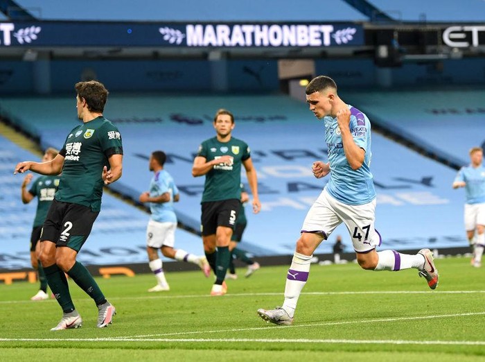 MANCHESTER, ENGLAND - JUNE 22: Phil Foden of Manchester City celebrates after scoring his teams fifth goal during the Premier League match between Manchester City and Burnley FC at Etihad Stadium on June 22, 2020 in Manchester, England. Football stadiums around Europe remain empty due to the Coronavirus Pandemic as Government social distancing laws prohibit fans inside venus resulting in all fixtures being played behind closed doors. (Photo by Michael Regan/Getty Images)