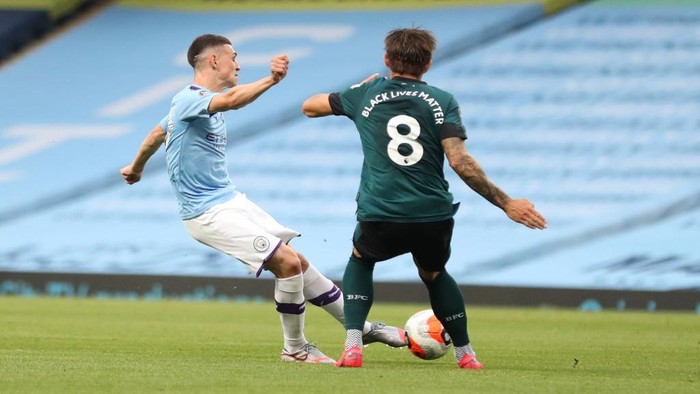 MANCHESTER, ENGLAND - JUNE 22: Phil Foden of Manchester City scores his teams first goal during the Premier League match between Manchester City and Burnley FC at Etihad Stadium on June 22, 2020 in Manchester, England. Football stadiums around Europe remain empty due to the Coronavirus Pandemic as Government social distancing laws prohibit fans inside venues resulting in all fixtures being played behind closed doors. (Photo by Martin Rickett/Pool via Getty Images)