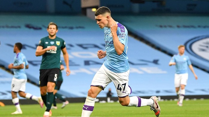 MANCHESTER, ENGLAND - JUNE 22: Phil Foden of Manchester City celebrates after scoring his teams fifth goal during the Premier League match between Manchester City and Burnley FC at Etihad Stadium on June 22, 2020 in Manchester, England. Football stadiums around Europe remain empty due to the Coronavirus Pandemic as Government social distancing laws prohibit fans inside venus resulting in all fixtures being played behind closed doors. (Photo by Michael Regan/Getty Images)