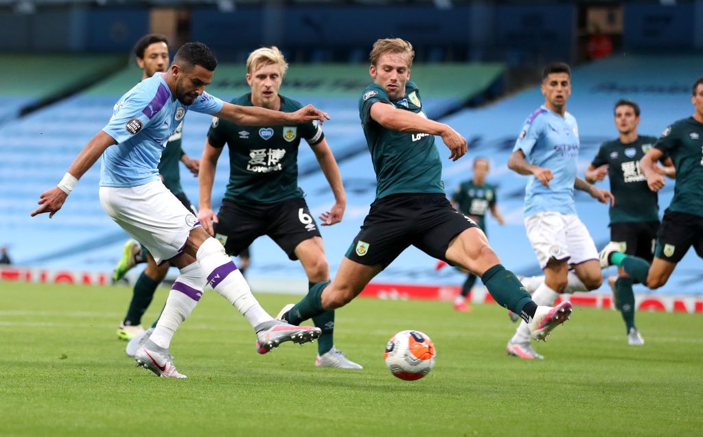 MANCHESTER, ENGLAND - JUNE 22: Riyad Mahrez of Manchester City scores his team's second goal during the Premier League match between Manchester City and Burnley FC at Etihad Stadium on June 22, 2020 in Manchester, England. Football stadiums around Europe remain empty due to the Coronavirus Pandemic as Government social distancing laws prohibit fans inside venues resulting in all fixtures being played behind closed doors. (Photo by Martin Rickett/Pool via Getty Images)