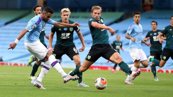 MANCHESTER, ENGLAND - JUNE 22: Riyad Mahrez of Manchester City scores his teams second goal during the Premier League match between Manchester City and Burnley FC at Etihad Stadium on June 22, 2020 in Manchester, England. Football stadiums around Europe remain empty due to the Coronavirus Pandemic as Government social distancing laws prohibit fans inside venues resulting in all fixtures being played behind closed doors. (Photo by Martin Rickett/Pool via Getty Images)