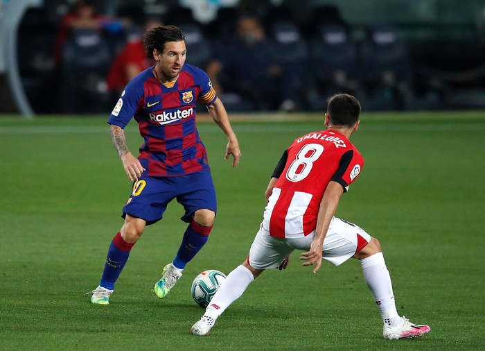 BARCELONA, SPAIN - JUNE 23: Lionel Messi of Barcelona takes on Unai Lopez of Athletic Bilbao during the Liga match between FC Barcelona and Athletic Club at Camp Nou on June 23, 2020 in Barcelona, Spain. Football Stadiums around Europe remain empty due to the Coronavirus Pandemic as Government social distancing laws prohibit fans inside venues resulting in all fixtures being played behind closed doors. (Photo by Eric Alonso/Getty Images)