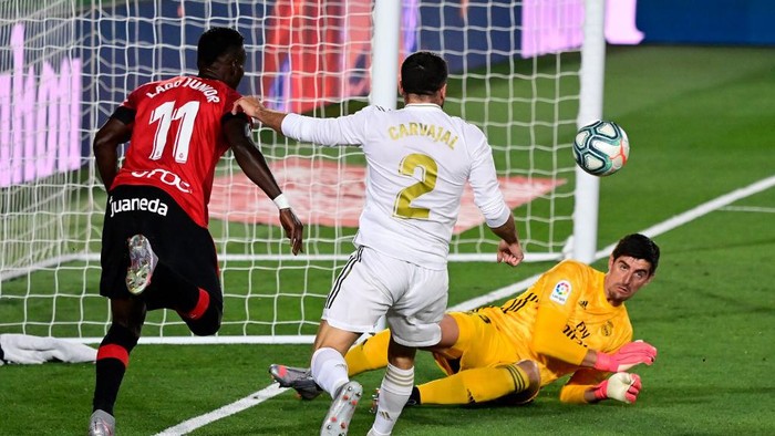 Real Mallorcas Ivorian forward Lago Junior (L) challenges  Real Madrids Belgian goalkeeper Thibaut Courtois and Real Madrids Spanish defender Dani Carvajal  during the the Spanish league football match real Real Madrid CF against RCD Mallorca at at the Alfredo di Stefano stadium in Valdebebas, on the outskirts of Madrid, on June 24, 2020. (Photo by JAVIER SORIANO / AFP)