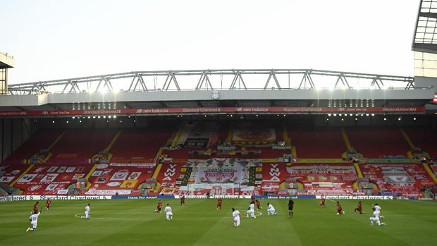Liverpool and Crystal Palace players take a knee before the English Premier League soccer match between Liverpool and Crystal Palace at Anfield Stadium in Liverpool, England, Wednesday, June 24, 2020. (Shaun Botterill/Pool via AP)