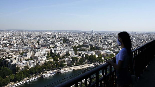 A visitor looks at the view from the Eiffel Tower, in Paris, Thursday, June 25, 2020. The Eiffel Tower reopens after the coronavirus pandemic led to the iconic Paris landmark's longest closure since World War II. (AP Photo/Thibault Camus)