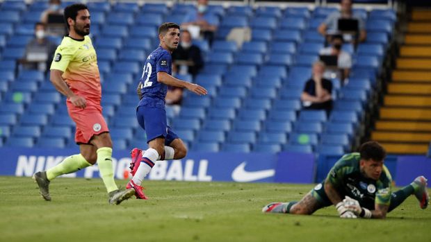 Chelsea's Christian Pulisic, centre, watches the ball as he scores his teams first goal during the English Premier League soccer match between Chelsea and Manchester City at Stamford Bridge, in London, England, Thursday, June 25, 2020. (AP Photo/Paul Childs,Pool)