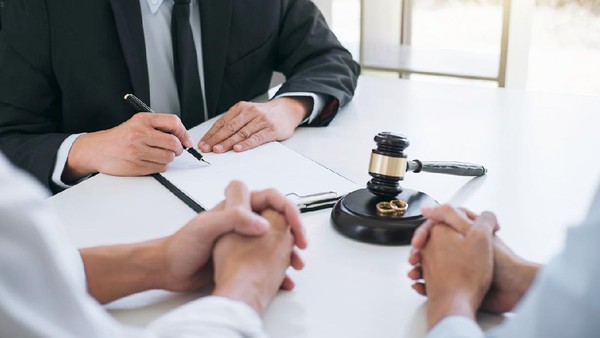 Ilustrasi Sidang Perceraian Agreement prepared by lawyer signing decree of divorce (dissolution or cancellation) of marriage, husband and wife during divorce process with male lawyer or counselor and signing of divorce contract.